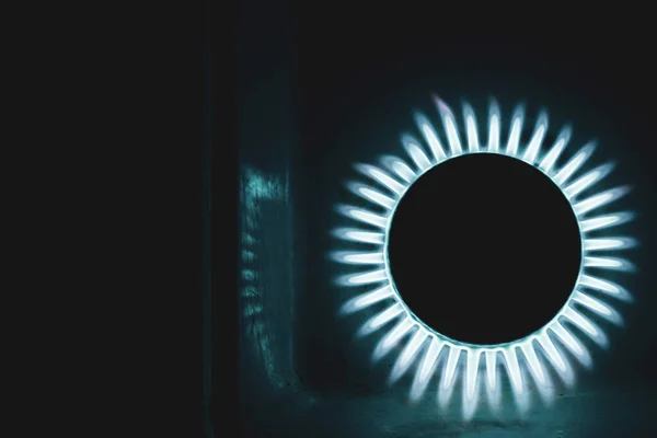 a hundred dollar bill on a gas burner with a burning fire on a black background, the front and back background is blurred with a bokeh effec