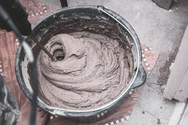 Çözümü çimento ve kum kovasında karıştırıcı ile yoğur