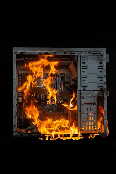 computer unit is burning with open fire and smoke from overheating, on a black isolated background