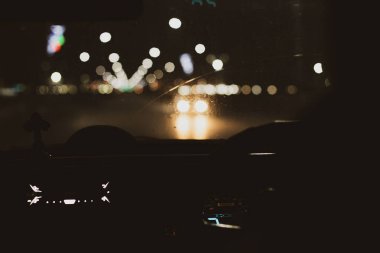 Gece yolu. İçeriden bak. Doğal ışık. Sokak ve diğer arabalar hareket bulanık.