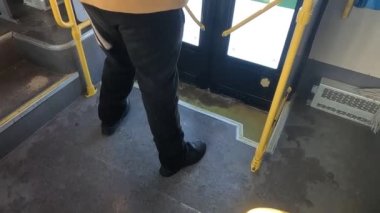İnsanlar gündüz vakti otobüs durağında toplu taşımadan iniyorlar.