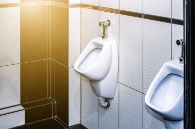 Erkekler tuvaletinde sırada beyaz pisuar var. Rahat erkek tuvaleti, modern temiz umumi tuvaletler.