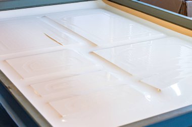 Bir MDF paneline film yapıştırmak için çalışan bir makine mühendisi ön ve arka plan bokeh etkisi ile bulanıklaşır.