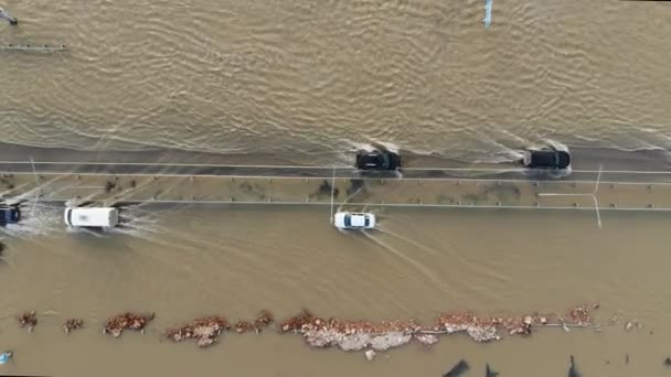 在洪水和洪水期间沿着被洪水淹没的公路行驶的汽车和卡车 — 图库视频影像