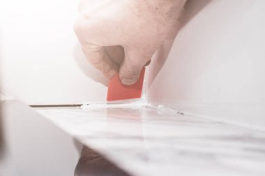 Porselen fayansların üzerinde plastik spatula ve silikon harç ile birleştirme, rahat bir yaşam için odaları tamamlama