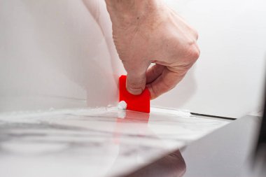 Porselen fayansların üzerinde plastik spatula ve silikon harç ile birleştirme, rahat bir yaşam için odaları tamamlama