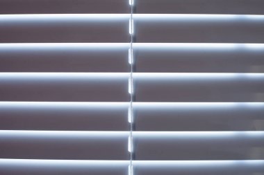 Günbatımında yatay metal panjurları morötesi ışığı engeller, arkaplan ve ön plan bokeh etkisi ile bulanıklaşır