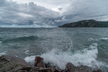 Superior Lake Park 'taki kayalık sahilde sörf. Kanada