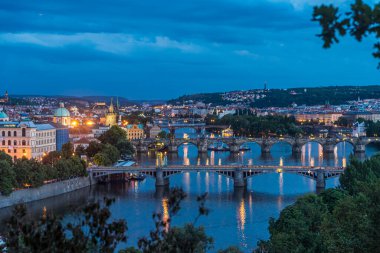 Prag şehir evlerinin, köprülerin ve ışıkların gece manzarası