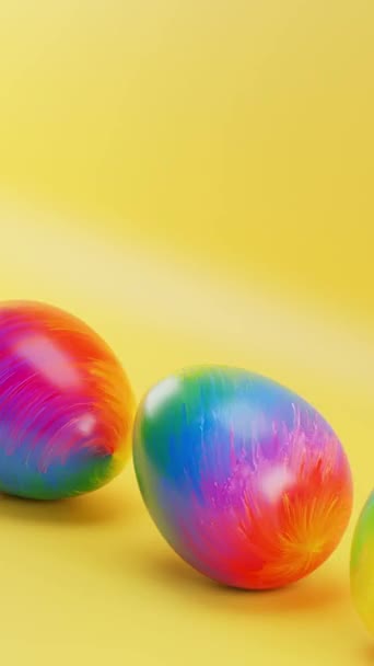 Три Барвисті Яйця Сидять Жовтій Поверхні Жовтим Тлом Вертикальна Петля — стокове відео
