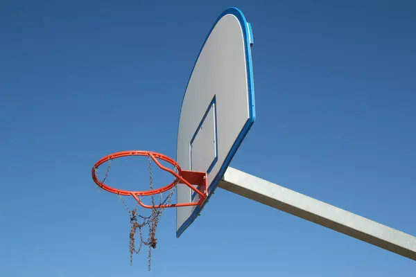 壊れた鎖の網および青い空が付いているオレンジ バスケットボールのホップ — ストック写真