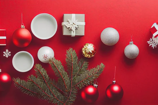 クリスマスのギフトは赤い背景にパッケージとクリスマスのモチーフの装飾品 — ストック写真