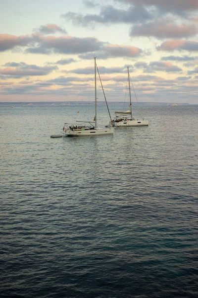 游船停泊在马略卡湾中 沐浴在夕阳西下的琥珀色的怀抱中 抓住了巴勒王朝宁静的本质 — 图库照片