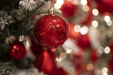 Parlak ışıkları ve renkli süslemeleri olan güzel dekore edilmiş bir Noel ağacı, neşeli ruhu somutlaştırıyor.
