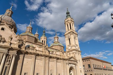 Parlak mavi gökyüzünün altında heykellerle süslenmiş Basilica del Pilar 'ın Barok cephesinin büyük ön görüntüsü.