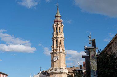 Bazilika del Pilar 'ın saat kulesine yakın çekim, tarihsel ve işlevsel mimarinin sakin bir gökyüzüne karşı birleşimi.