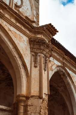 Dikey çekim, bulutlu bir gökyüzüne karşı Manastır de Piedra 'nın kilisesinin yıpranmış harabelerinin çetrefilli cephelerini yakalıyor..