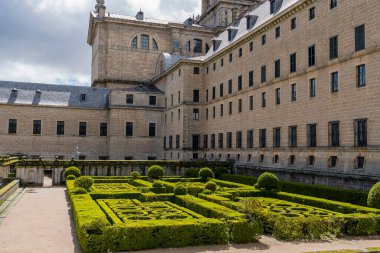 Kraliyet Escorial Manastırı 'nın bahçeleri, Madrid' in dramatik gökyüzünün altında manzaralı bir arka plana karşı kusursuz geometrik çalılar sergiliyor.