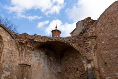 Dikey çekim, bulutlu bir gökyüzüne karşı Manastır de Piedra 'nın kilisesinin yıpranmış harabelerinin çetrefilli cephelerini yakalıyor..