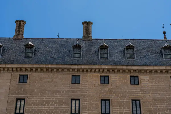 埃斯科利尔修道院的雕塑细节和标志性的穹顶在蓝天和蓬松的云彩中显得格外醒目 免版税图库照片