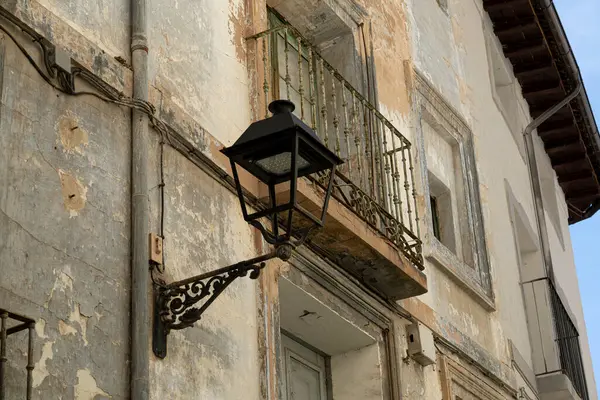 一盏旧路灯挂在一座漆成剥皮的建筑物上 凸显了城市衰败的乡村魅力 图库图片