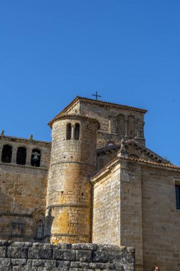 Santillana del Mar, Cantabria, İspanya 'daki Santa Juliana Kolej Kilisesi' nin çan kulesine yakın çekim. Ortaçağ taş mimarisi açık mavi gökyüzüne karşı duruyor..