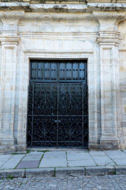 Santillana del Mar, Cantabria, İspanya 'daki tarihi çan kulesinin yakın görüntüsü. Antik taş mimarisi açık mavi gökyüzüne karşı duruyor..