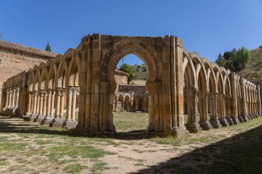 The historic cloister of Monasterio de San Juan de Duero in Soria, Spain, showcasing its iconic arches and ancient stone architecture on a bright sunny day clipart