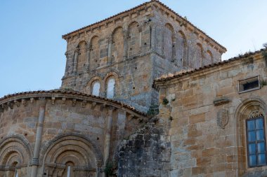 Santillana del Mar, Cantabria, İspanya 'daki Santa Juliana Kolej Kilisesi' nin çan kulesine yakın çekim. Ortaçağ taş mimarisi açık mavi gökyüzüne karşı duruyor..