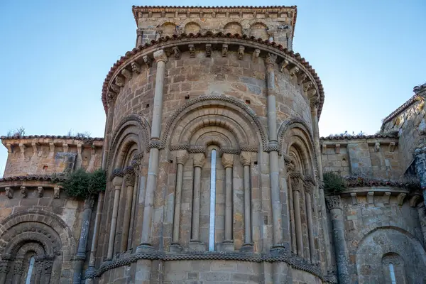 stock image Close-up of the bell tower of the Collegiate Church of Santa Juliana in Santillana del Mar, Cantabria, Spain. The medieval stone architecture stands against a clear blue sky.