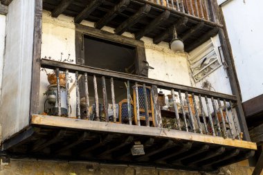 İspanya 'nın Santillana del Mar kentindeki tarihi bir binanın kırsal ahşap balkonuna yakın çekim. Büyüleyici mimari ayrıntılar bölgenin kültür mirasını vurguluyor