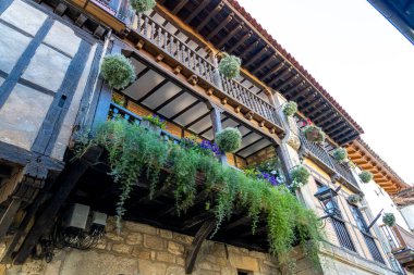 İspanya 'nın Santillana del Mar kentindeki tarihi bir binanın kırsal ahşap balkonuna yakın çekim. Büyüleyici mimari ayrıntılar bölgenin kültür mirasını vurguluyor