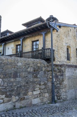 İspanya, Santillana del Mar 'da taştan yapılma antika bir cadde. Taştan binalar ve çiçeklerle süslenmiş balkonları var. Seyahat, mimari ve kültürel temalar için ideal