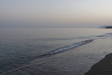 İspanya 'nın Malaga kentindeki sakin bir sahilde alacakaranlıkta hafif dalgalar kıyıya vurur. Rahatlama, kıyı dinginliği ve doğanın güzelliği için mükemmel bir tema..