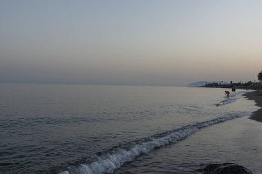 İspanya 'nın Malaga kentindeki sakin bir sahilde alacakaranlıkta hafif dalgalar kıyıya vurur. Rahatlama, kıyı dinginliği ve doğanın güzelliği için mükemmel bir tema..