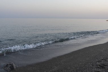 İspanya 'nın Malaga kentindeki sakin bir sahilde alacakaranlıkta hafif dalgalar kıyıya vurur. Rahatlama, kıyı dinginliği ve doğanın güzelliği için mükemmel bir tema..