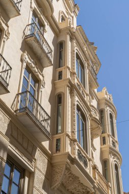 İspanya 'nın Malaga şehrinde, pencereleri ve saksıları kapalı geleneksel balkonların bulunduğu büyüleyici bir cephe. İspanyol mimarisini, kültürünü ve şehir estetiğini resmetmek için mükemmel.