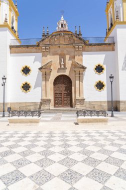 İspanya 'nın Ronda kentindeki Nuestra Senora de la Merced Kilisesi' nin göz kamaştırıcı cephesinde, parlak mavi gökyüzünün altında ikiz çan kuleleri ve merkezi bir çeşme bulunuyor. İspanyol mimarisi, dini simgeler ve kültür turizmi için mükemmel bir tema.