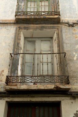 Antik bir balkonun yakın çekimi. Yaşlanan bir şehir binasının duvarları süslenmiş.