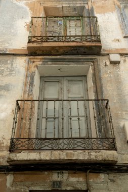 Antik bir balkonun yakın çekimi. Yaşlanan bir şehir binasının duvarları süslenmiş.