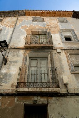 Antik bir balkonun yakın çekimi. Yaşlanan bir şehir binasının duvarları süslenmiş.