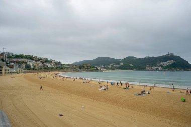 Bulutlu Gökyüzü ve Ziyaretçileri olan San Sebastian Plajı