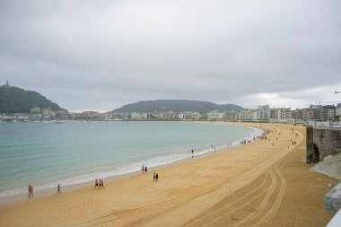 Bulutlu Gökyüzü ve Kıyı Gezginleriyle San Sebastian Plajı