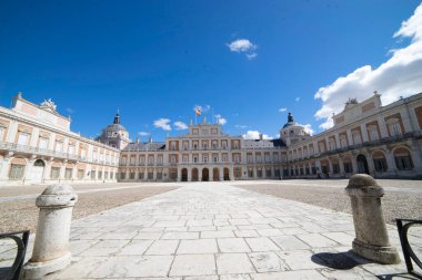 Ziyaretçiler, Aranjuez Kraliyet Sarayı 'nın göz kamaştırıcı mimarisine hayran. Açık avlular ve yemyeşil bahçelerle çevrili. Güneşli havanın ve tarihsel güzelliğin tadını çıkarıyorlar..