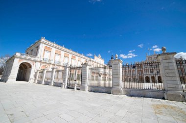 İspanya 'nın Aranjuez kentindeki kraliyet sarayının çarpıcı mimari detayları, parlak mavi gökyüzünün arka planına karşı. Açık hava bu tarihi yerin güzelliğini vurguluyor..