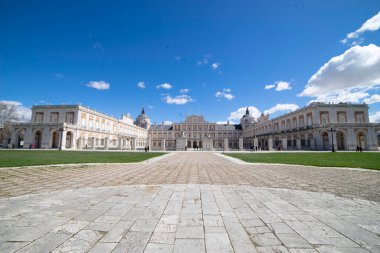Ziyaretçiler, bereketli bahçeler ve tarihi mimariyle çevrili görkemli Aranjuez Sarayı 'nı keşfederek İspanya' da güneşli bir günde güzel bir manzara yaratıyorlar..