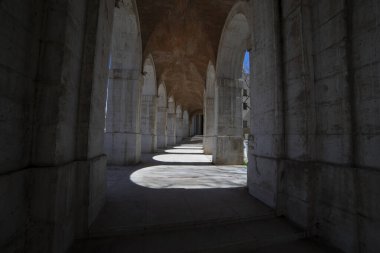 Aranjuez 'de sakin bir geçitte gezinmek, güneş ışığı filtreleri, taş zeminde güzel bir gölge ve ışık etkileşimi yaratır..