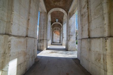 Ziyaretçiler, 18. yüzyılın kraliyet sarayının çarpıcı mimarisine hayran kalarak Aranjuez 'in zarif eski kemerlerinden geçiyorlar..