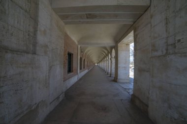 İspanya, Aranjuez 'deki eski kemerlerle zarif geçitten yürüyün, 18. yüzyıl kraliyet sarayına ziyaretçileri bağlayan, şimdi zengin tarihin sergilendiği bir müze.