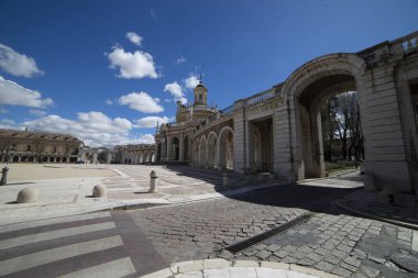 Ziyaretçiler, İspanya 'nın Aranjuez kentindeki sıcak güneşin ve açık gökyüzünün keyfini çıkarırken, dağınık bulutların çerçevelediği kraliyet bahçelerinin ve saray kompleksinin görkemli mimari özelliklerini keşfediyorlar..